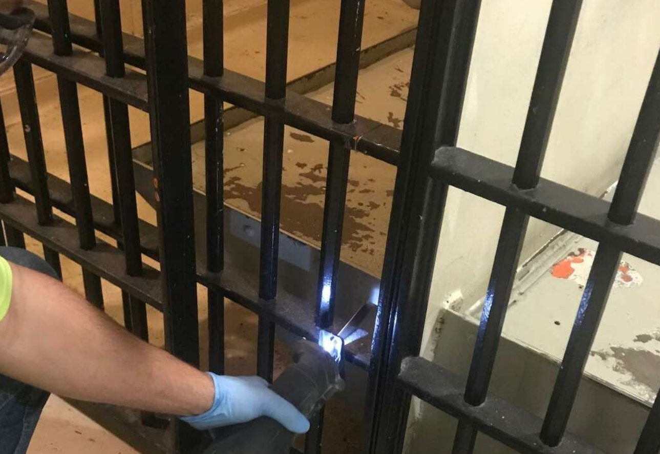 An experienced technician working on a large metal gate for a residential property, showcasing professional gate repair services in Orlando, Florida.